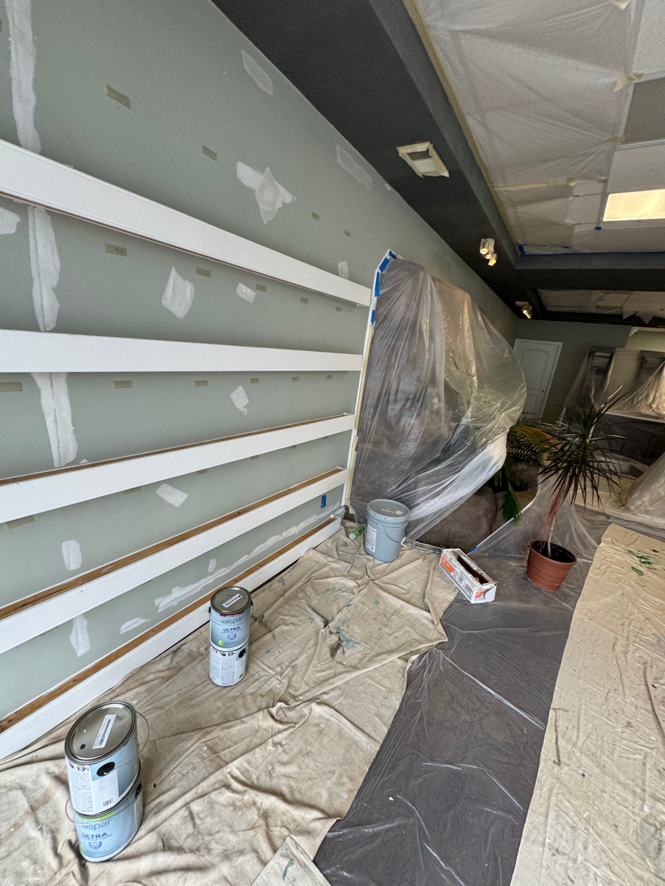 Sage green office wall with fresh white trim and shelving