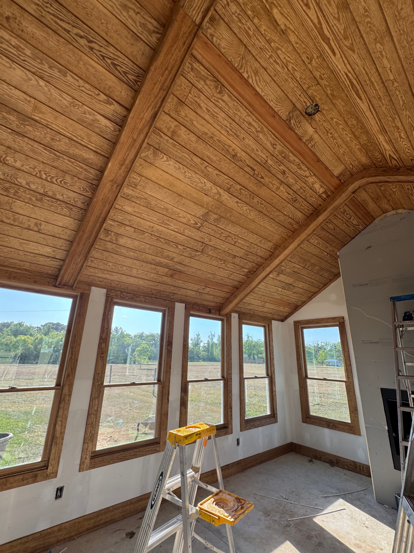 Stained tongue-and-groove vaulted wood ceiling in a sunroom